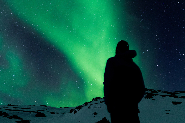 Man watching Northern Lights in Swedish Lapland